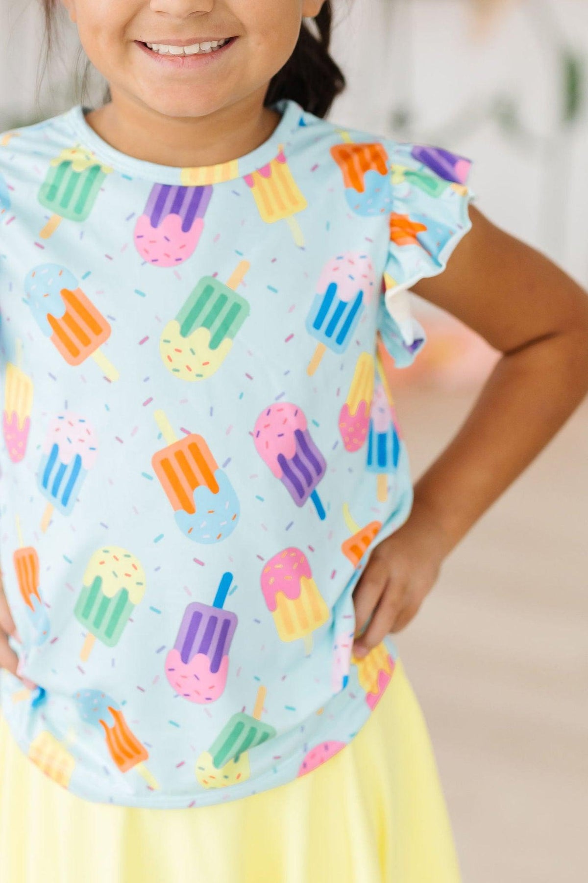 a girl wearing a blue shirt with ice cream on it