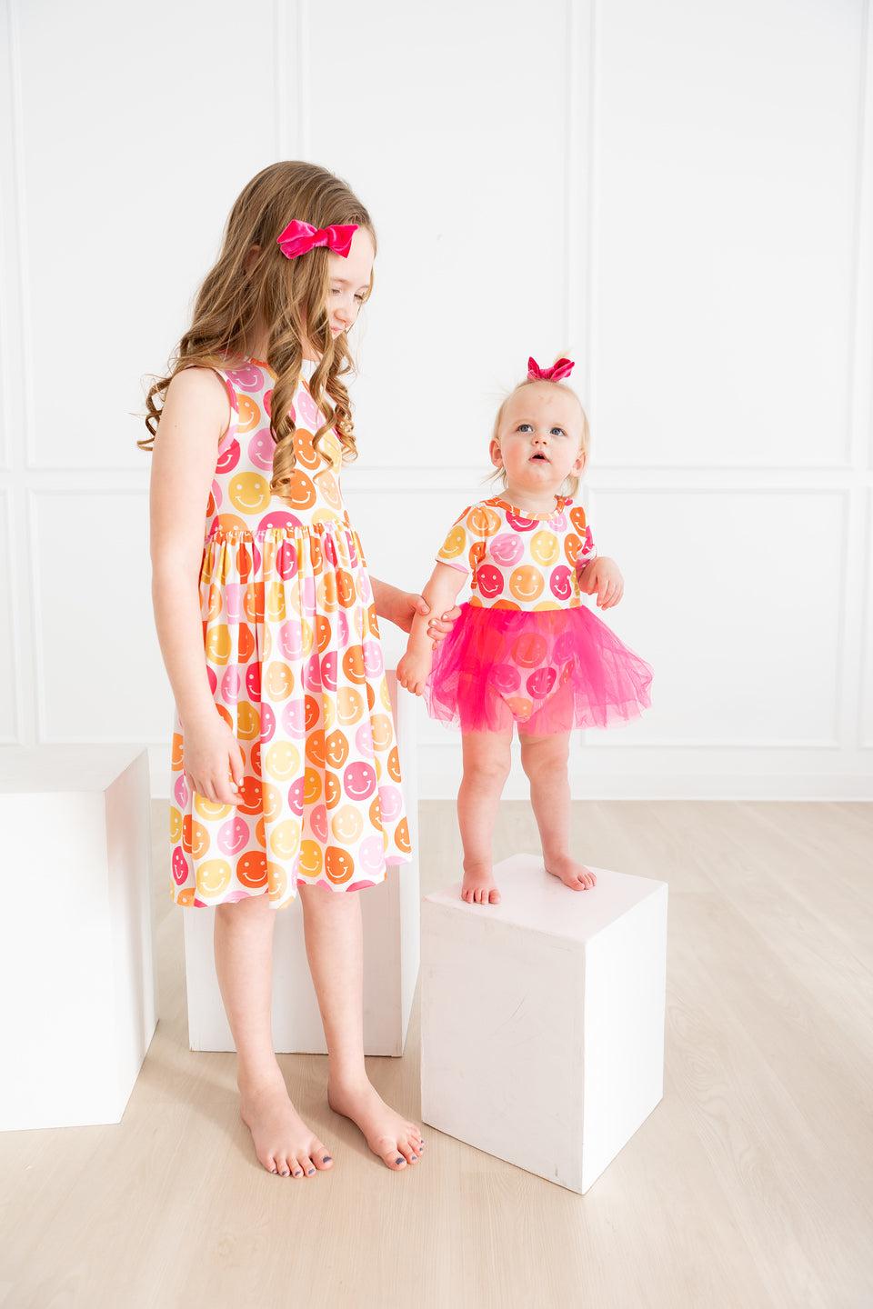 two girls standing on cubes