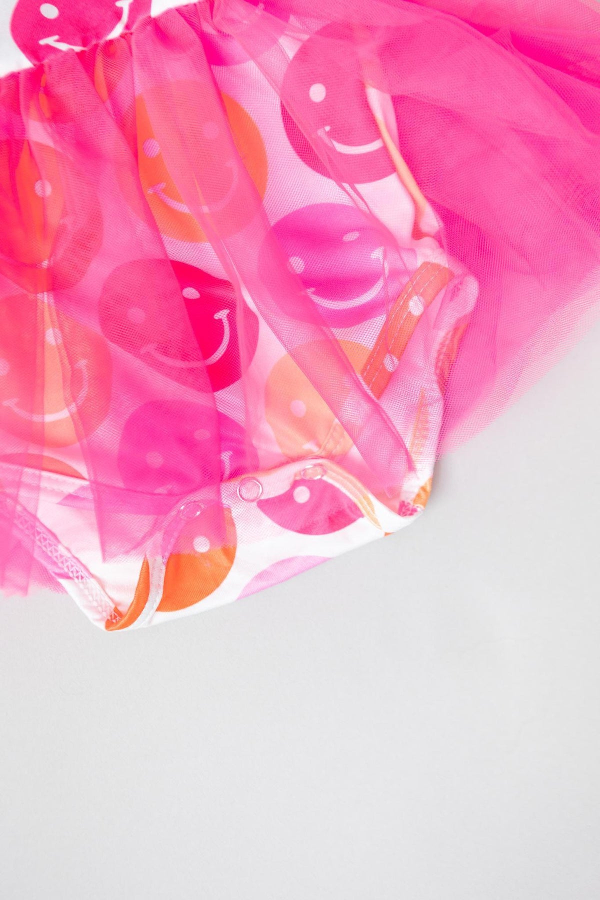 a pink tutu with smiley faces on it