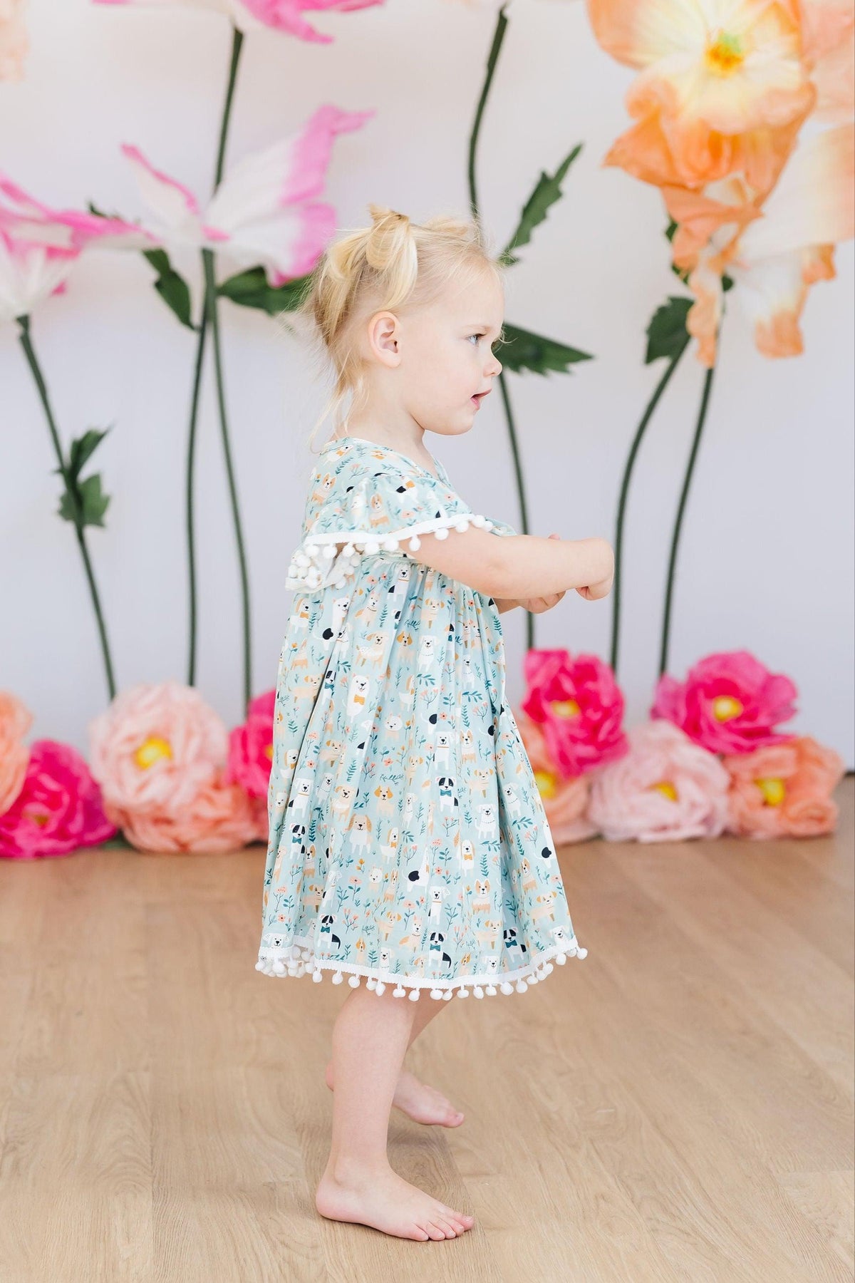 a girl standing in front of flowers