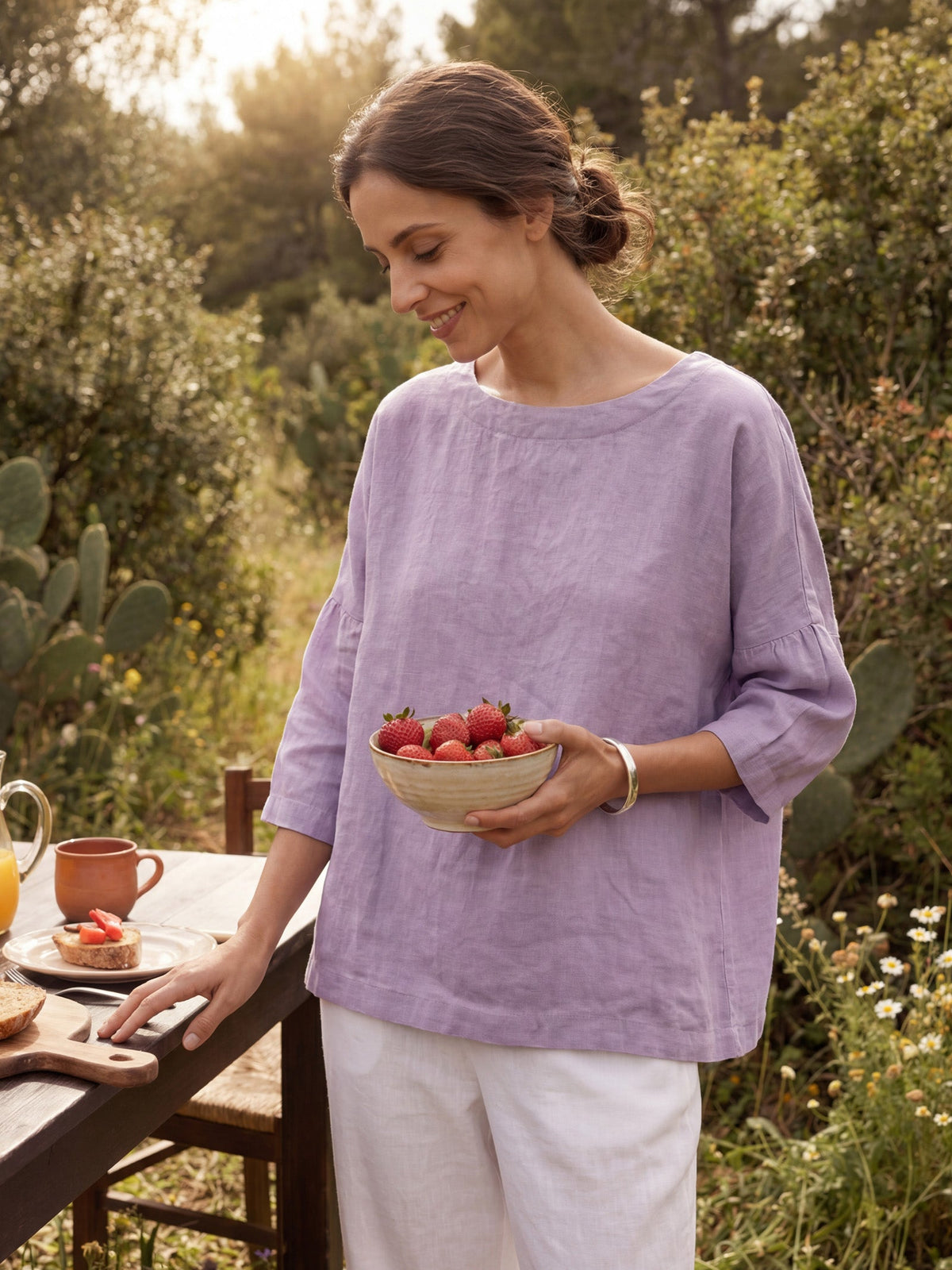 a woman holding a bowl of strawberries