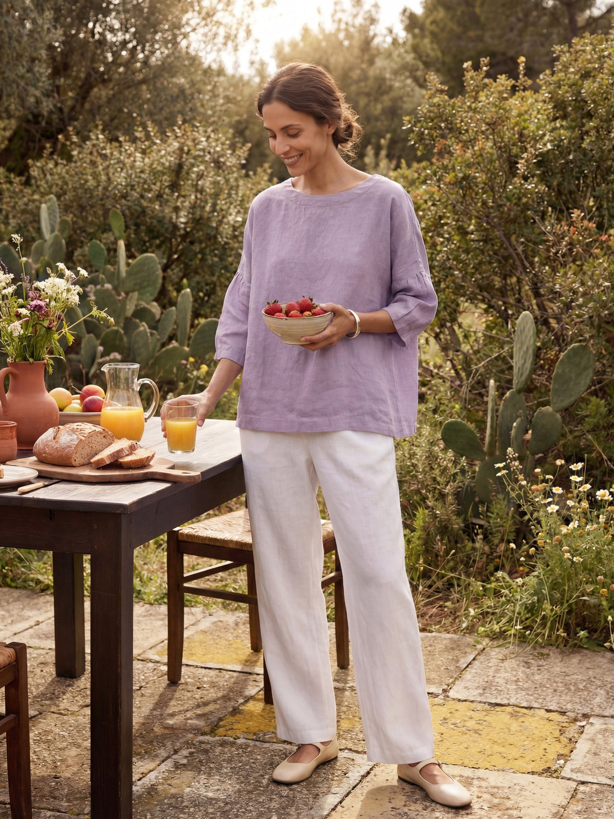a woman holding a bowl of fruit and a glass of juice
