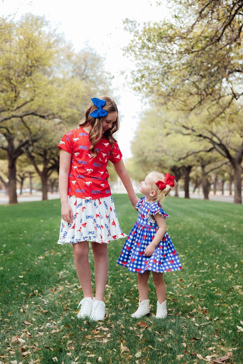 two girls standing on grass