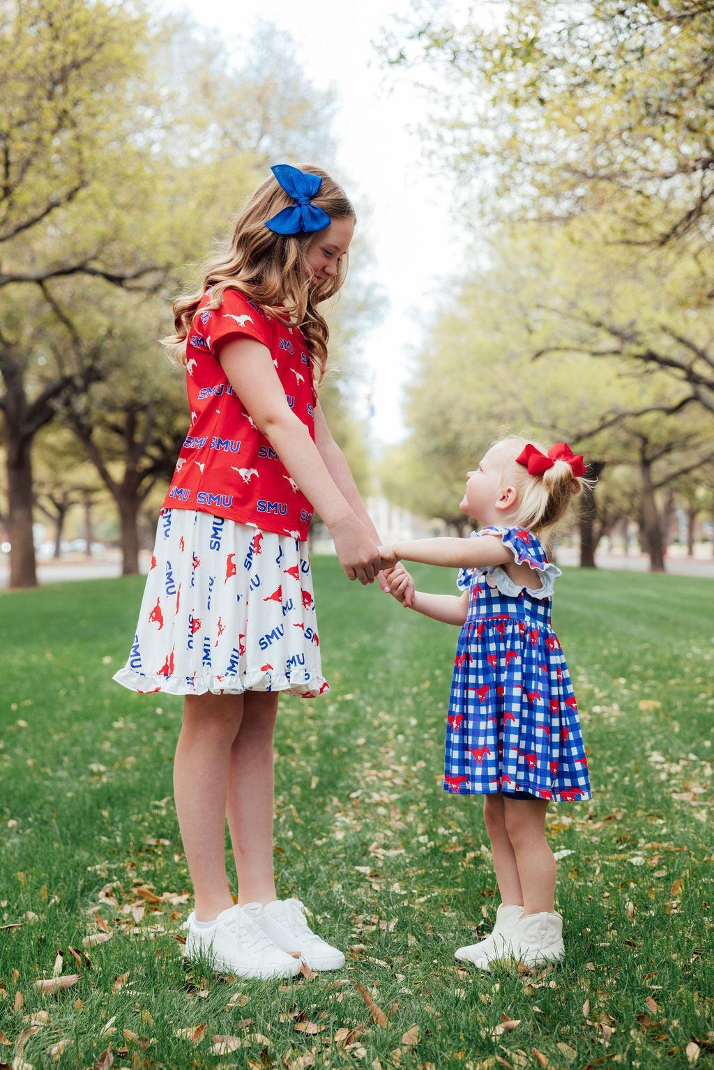 two girls holding hands in a park