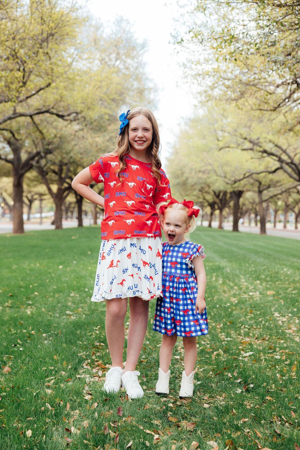 two girls standing in grass