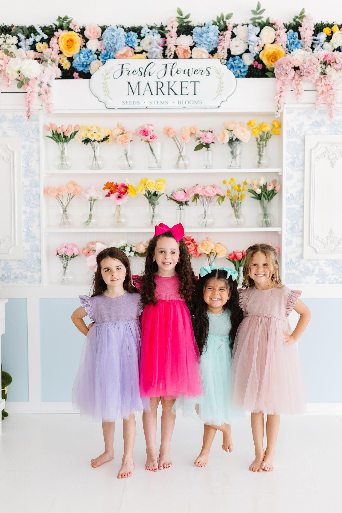 a group of girls in dresses posing for a photo