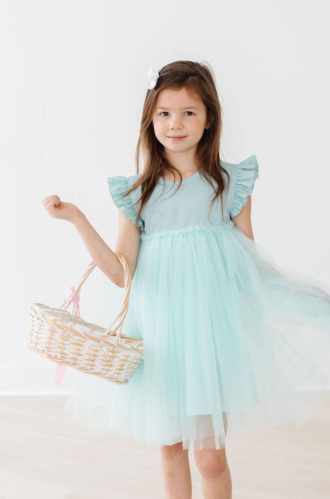 a girl in a dress holding a basket
