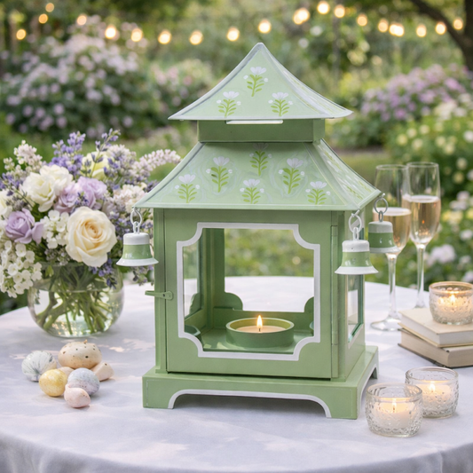 a green lantern with a candle on a table with flowers and candles