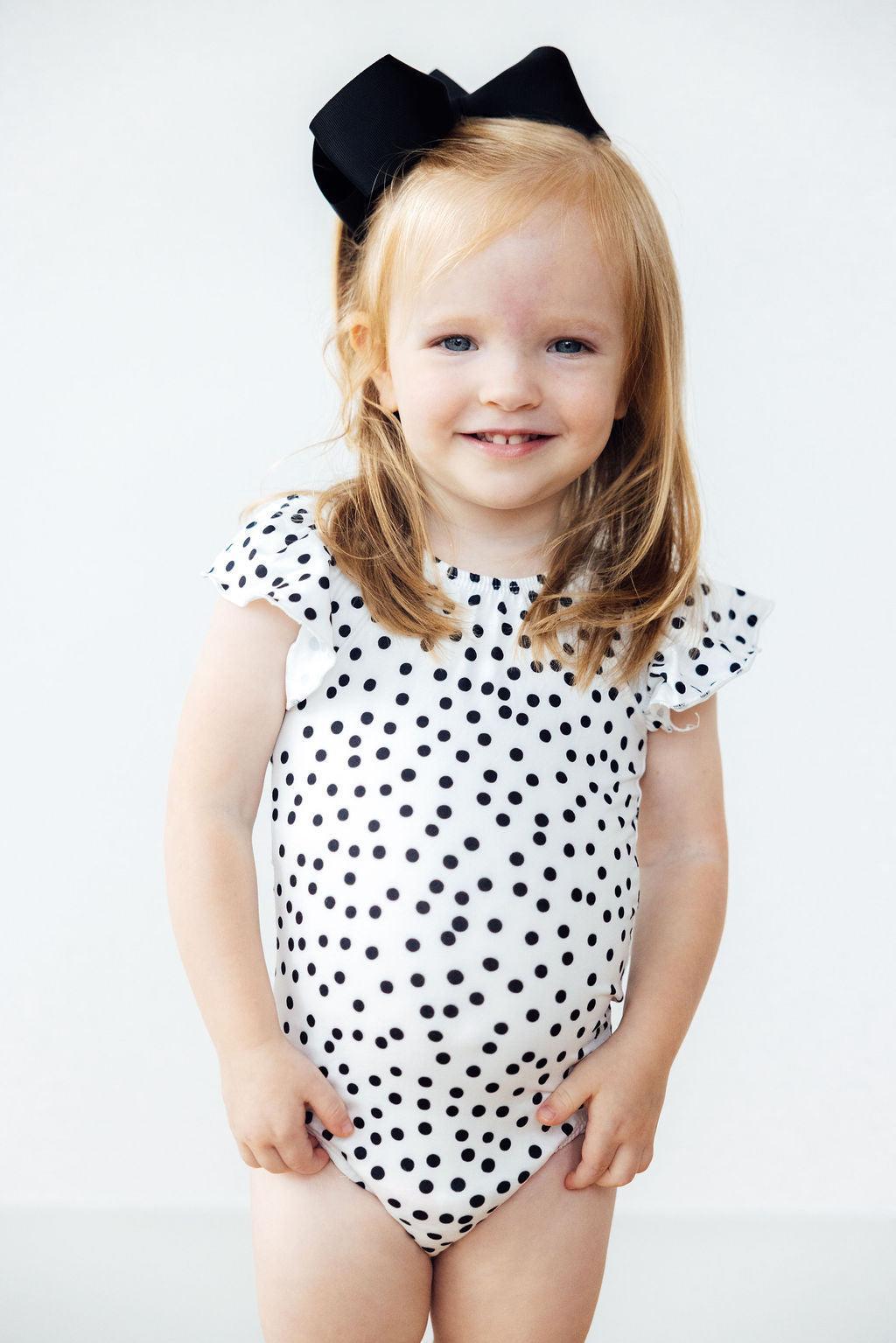 a girl in a polka dot dress