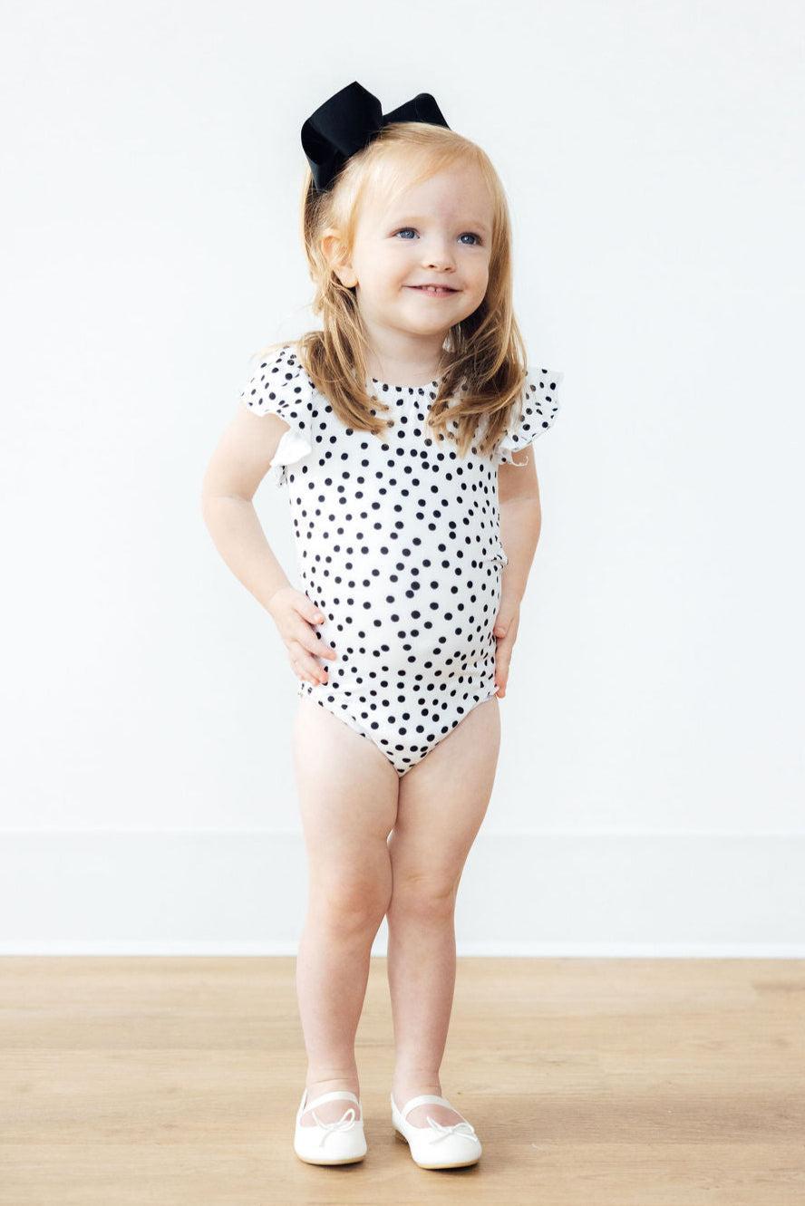 a girl in a polka dot swimsuit