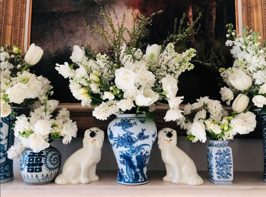 a group of white flowers in blue and white vases