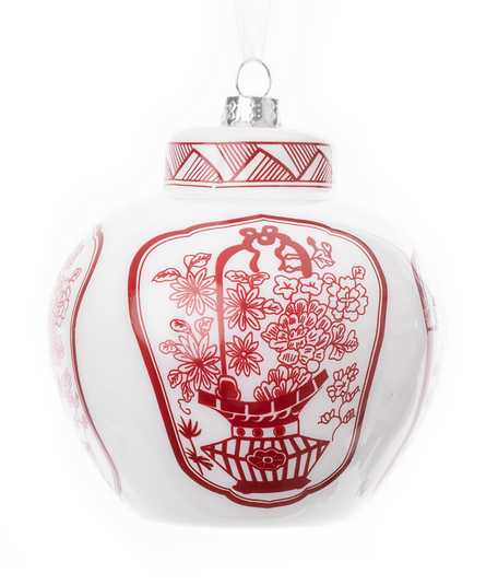 a white and red vase with a floral design