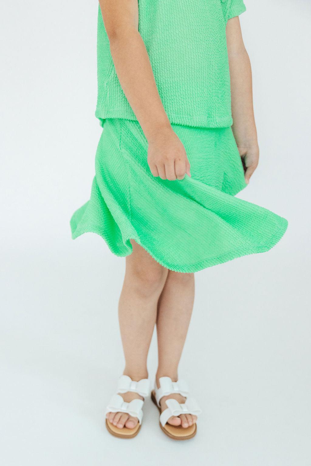 a child wearing a green skirt