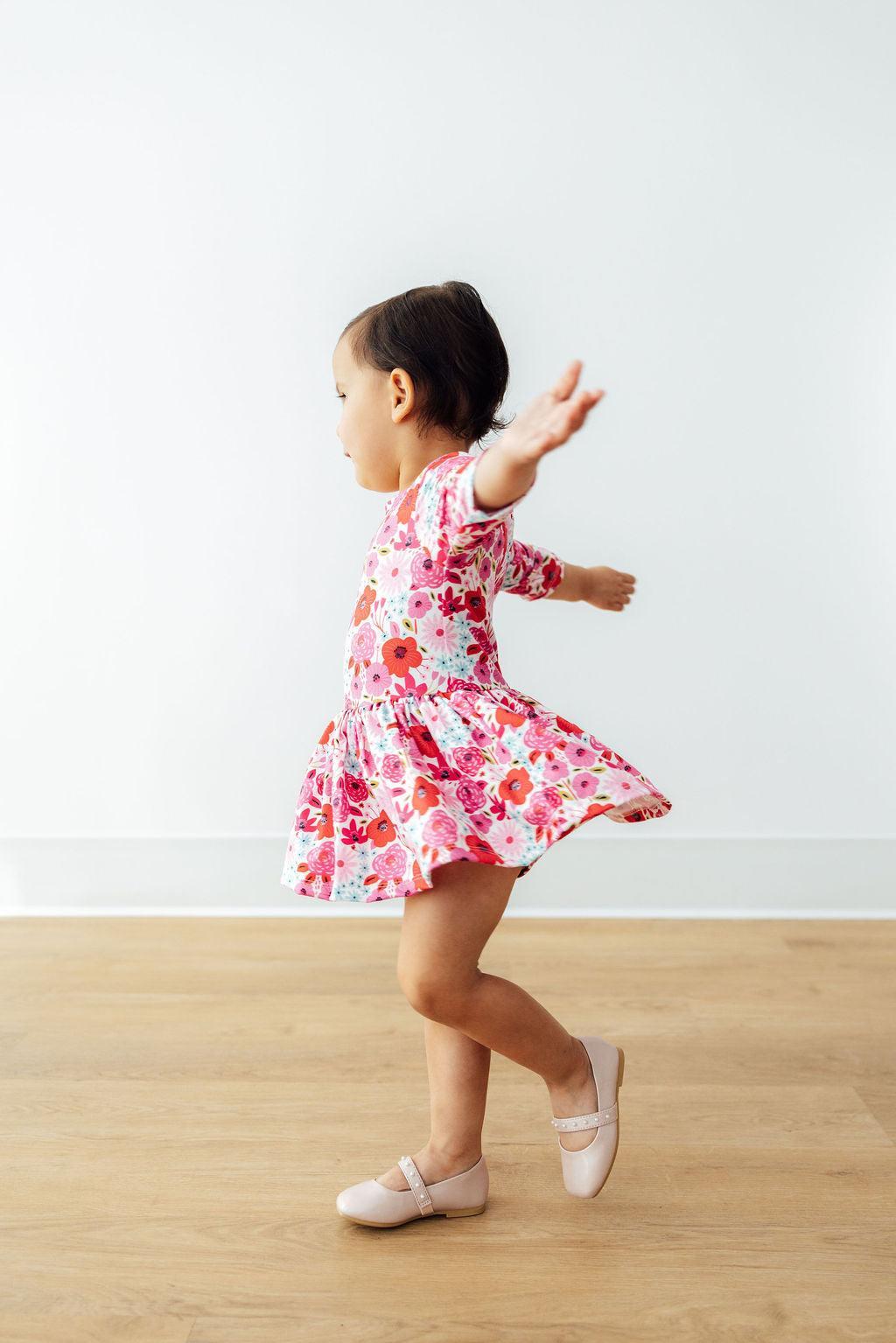 a child in a pink dress dancing