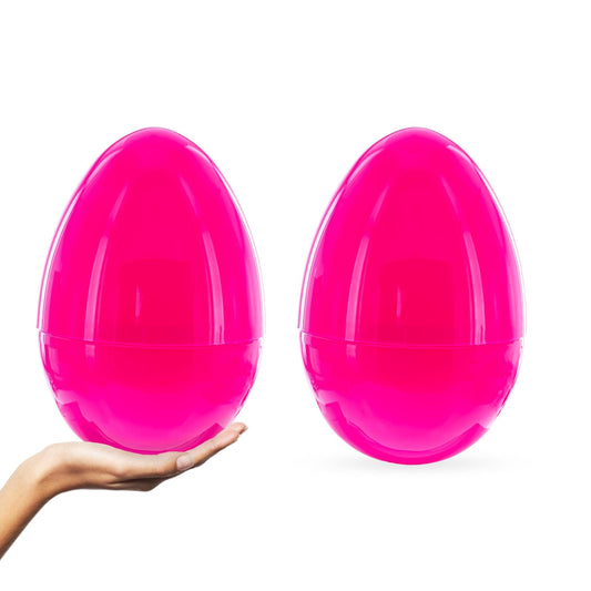 a hand holding two pink plastic eggs