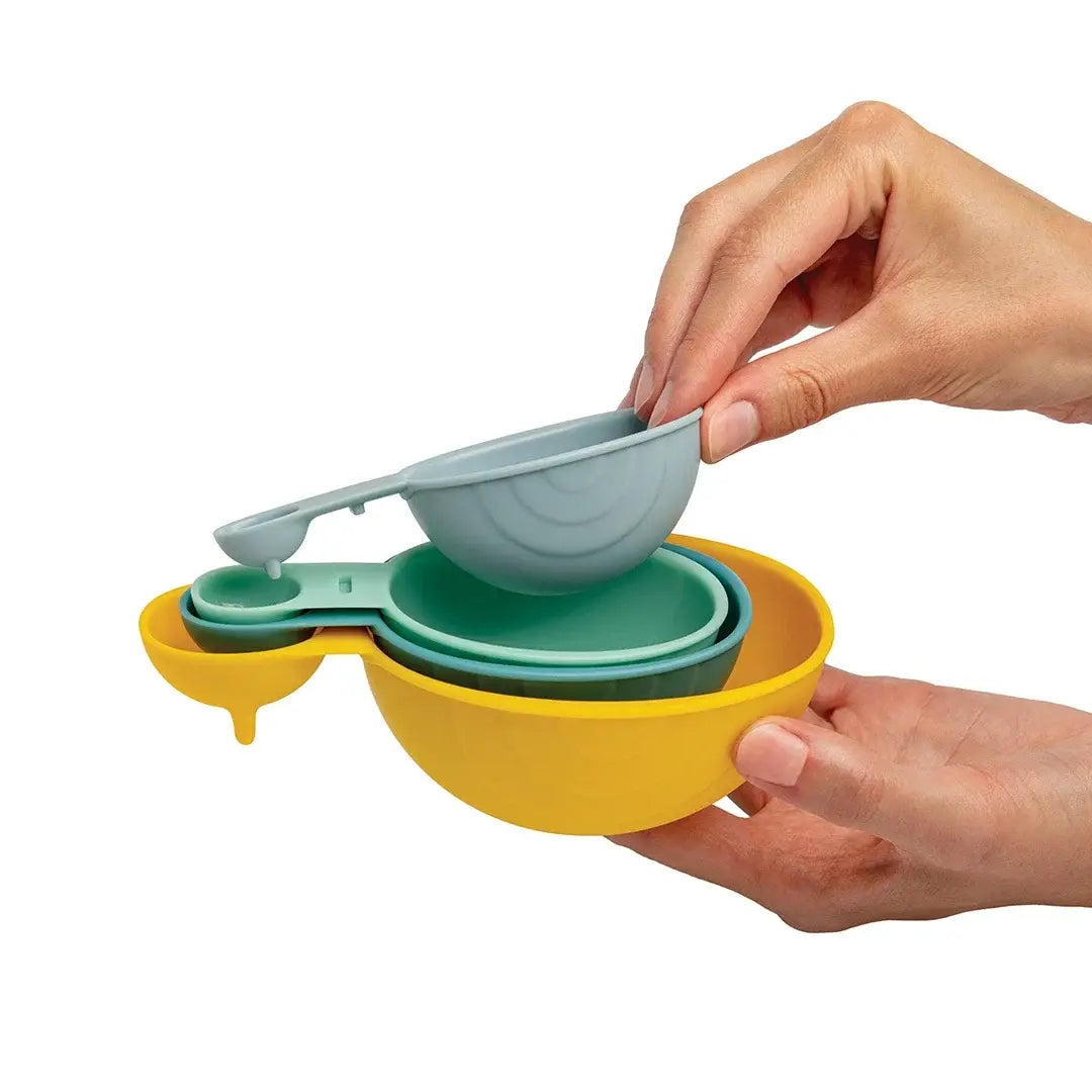 a hand holding a measuring cup