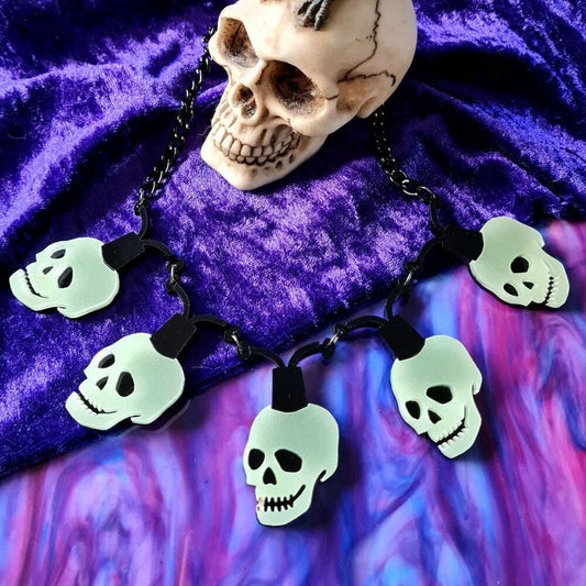 a skull necklace on a purple surface
