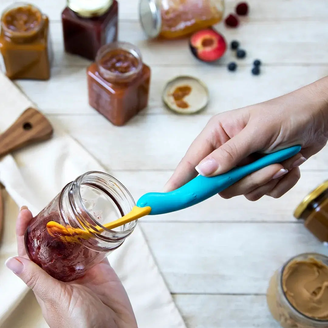 a person holding a jar with a spoon