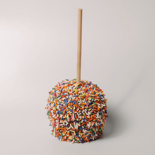 a candy apple with sprinkles on top