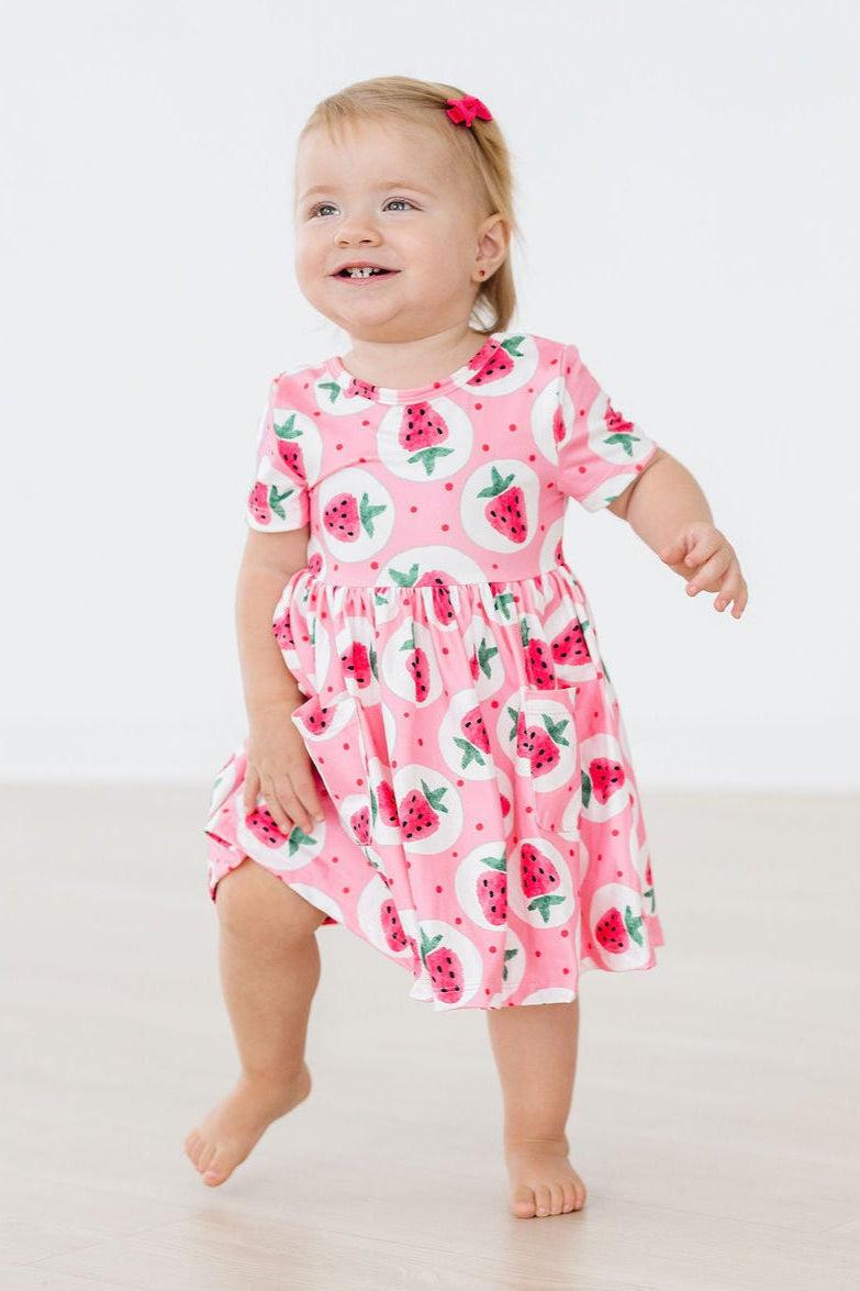 a baby girl in a pink dress