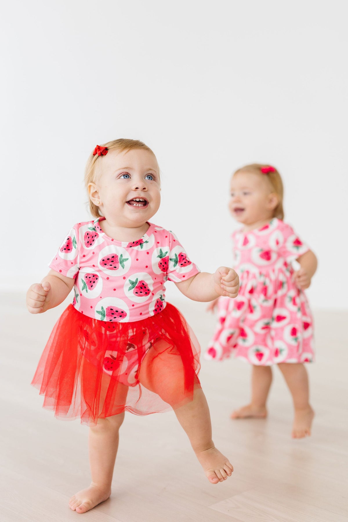 two babies in pink dresses