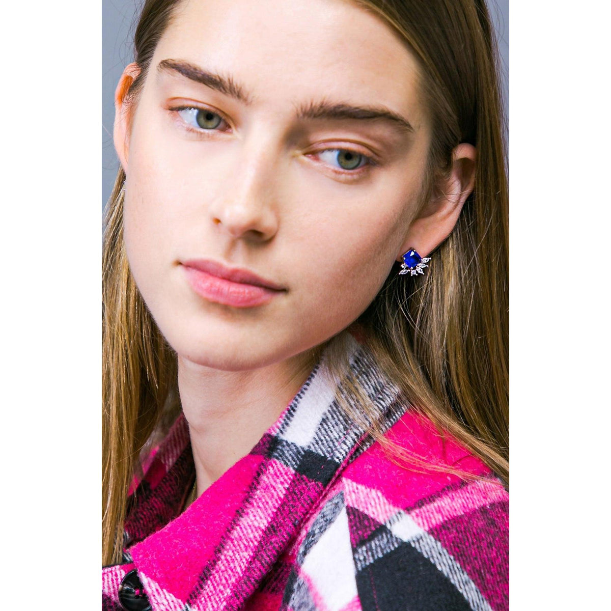a woman with long hair wearing a pink plaid jacket