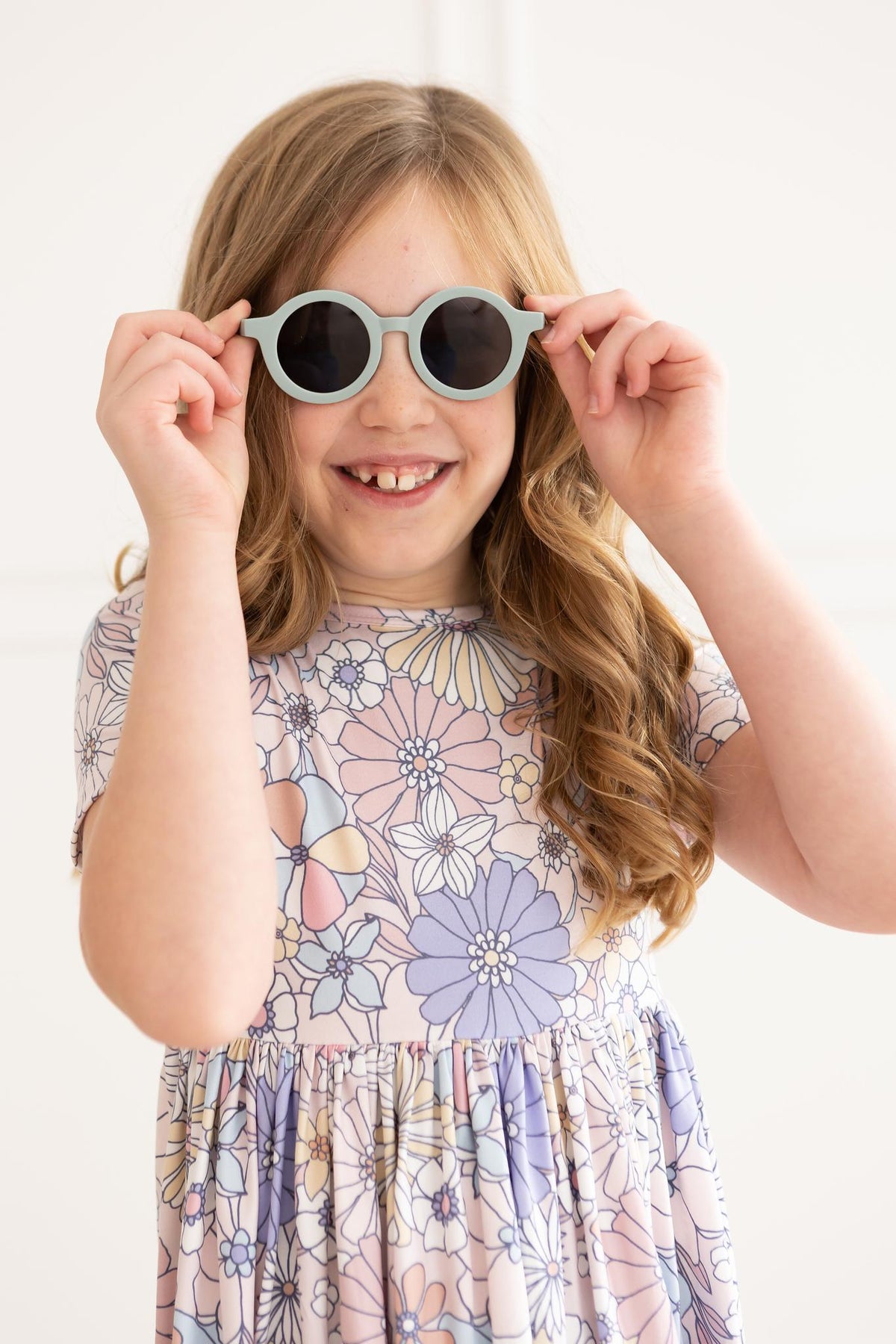 a girl wearing sunglasses and smiling