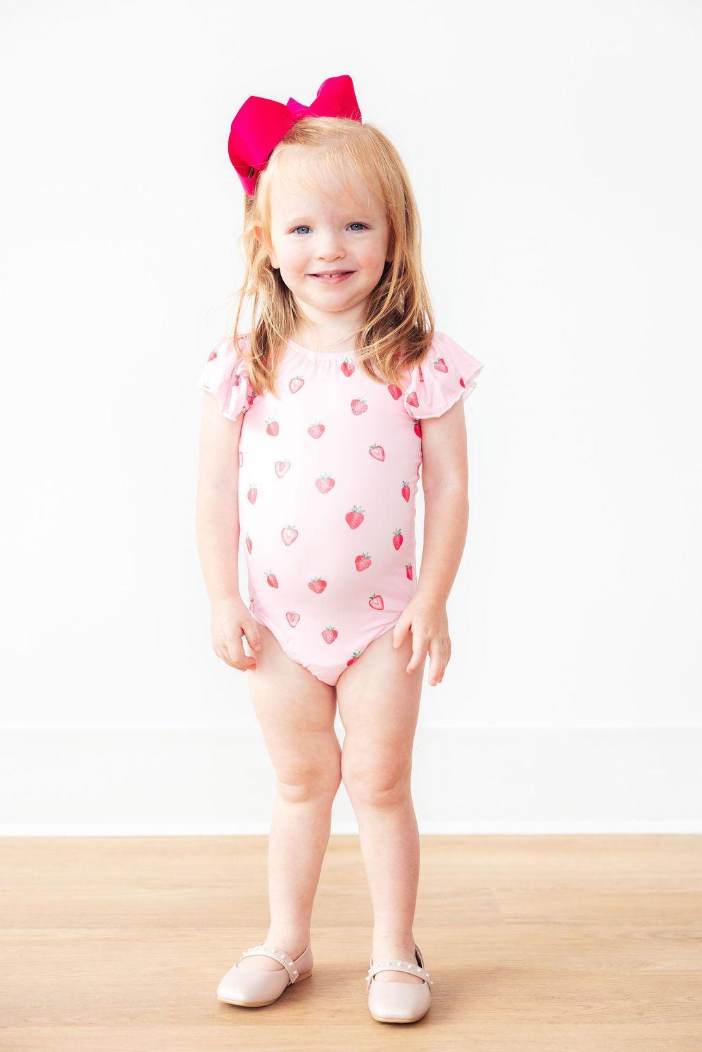 a girl in a pink bathing suit