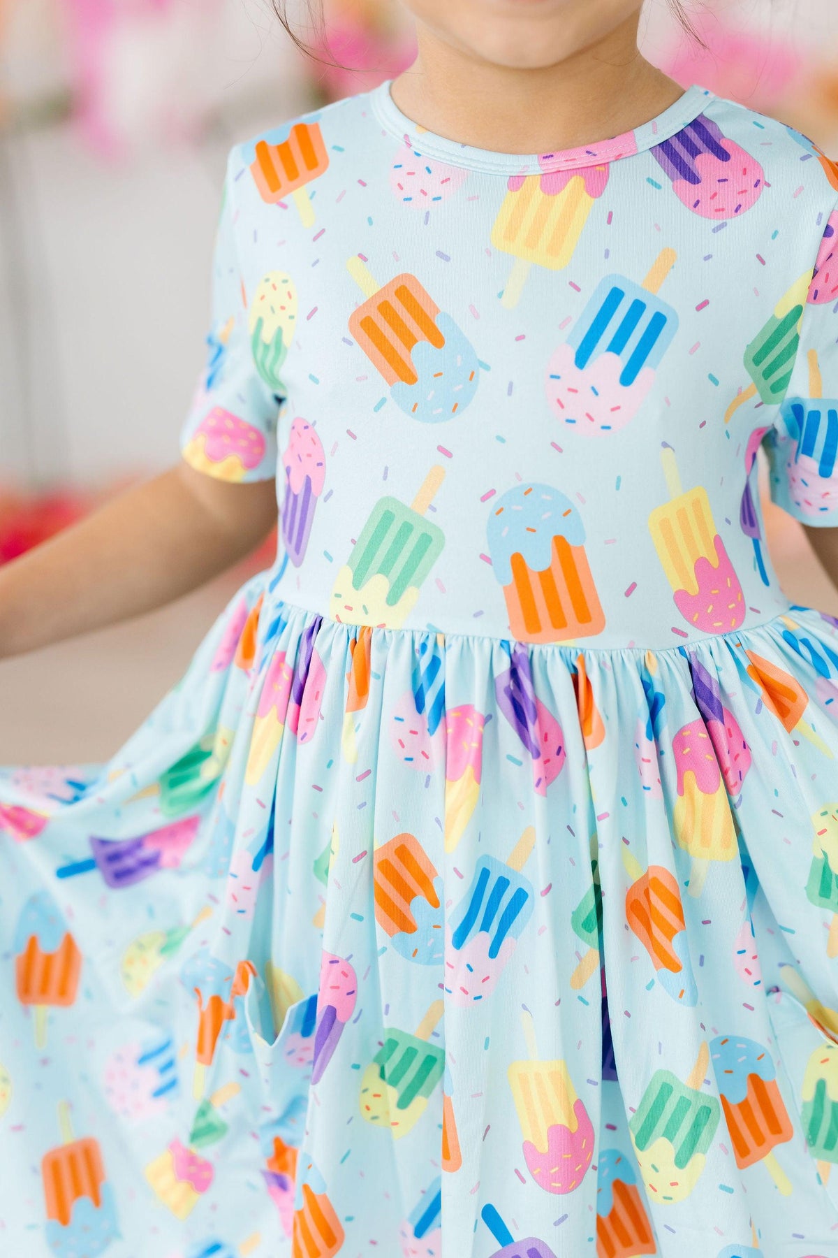 a child wearing a dress with ice cream on it