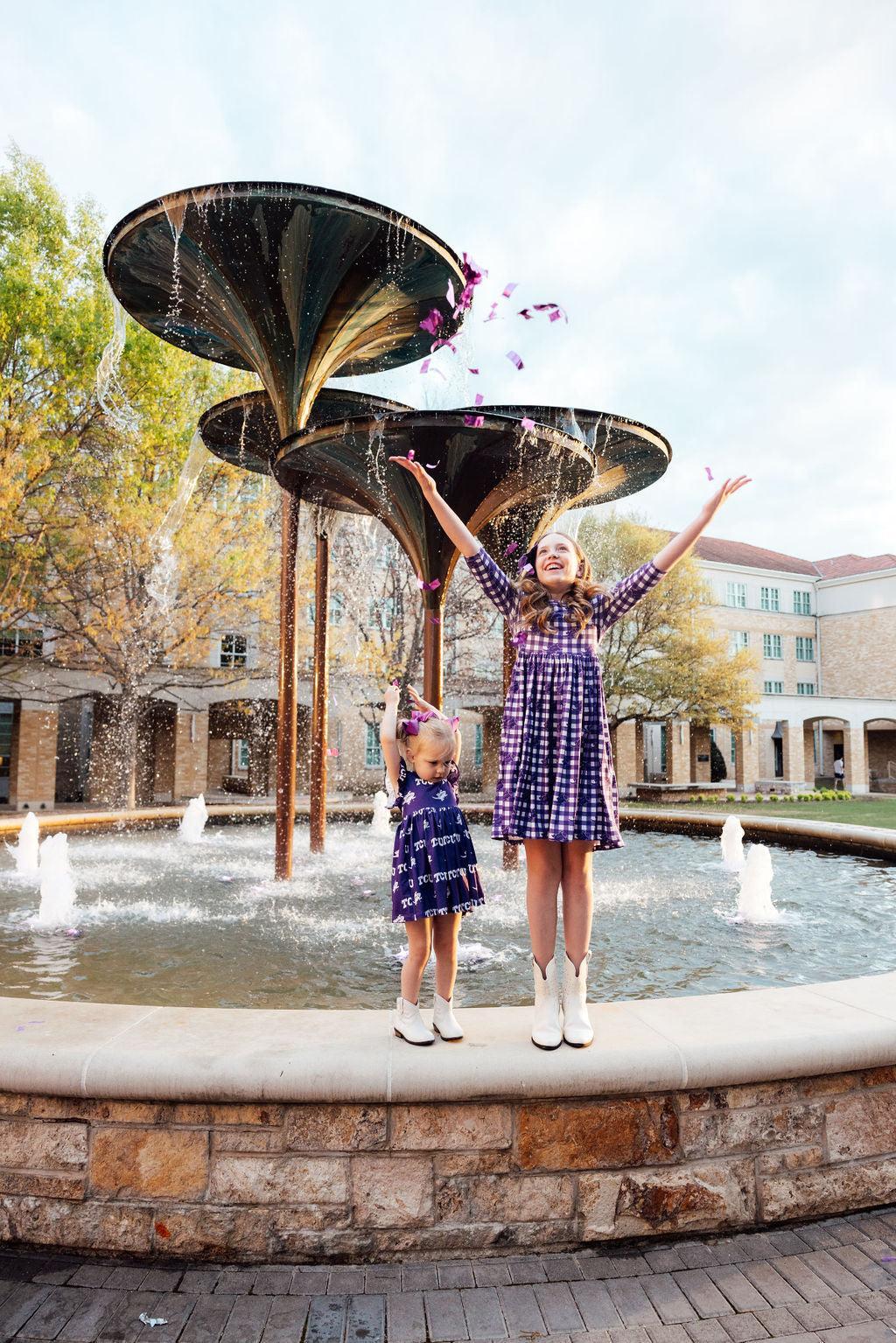 two girls standing in front of a fountain