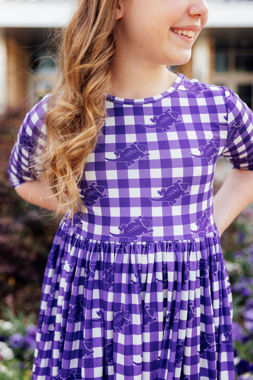 a girl in a purple and white checkered dress