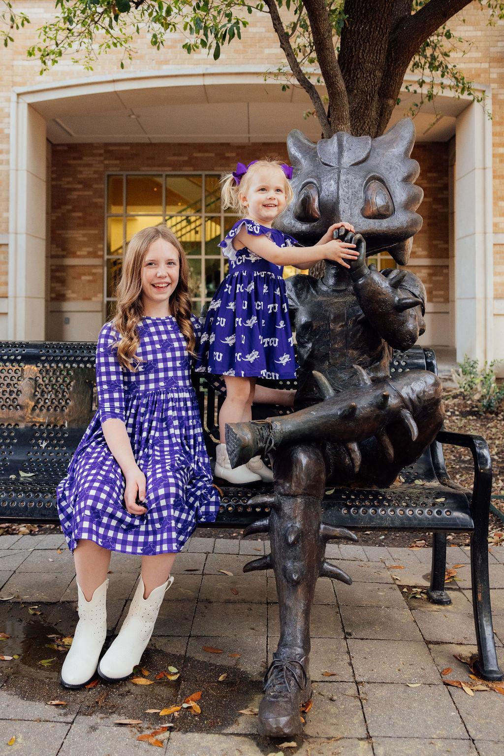 two girls posing for a picture on a bench