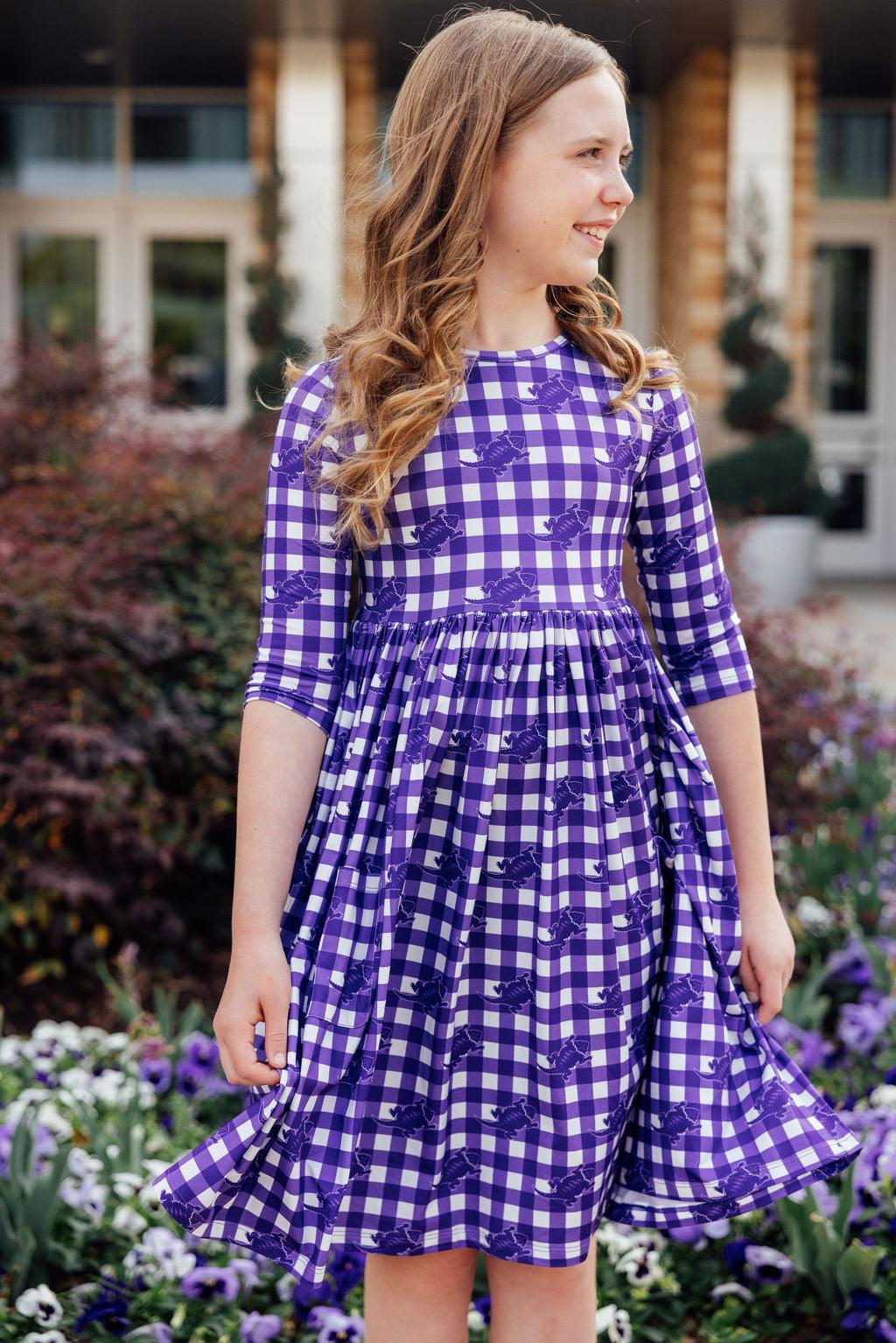 a girl in a purple and white checkered dress