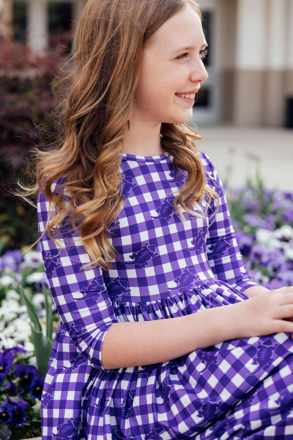 a girl in a purple and white checkered dress