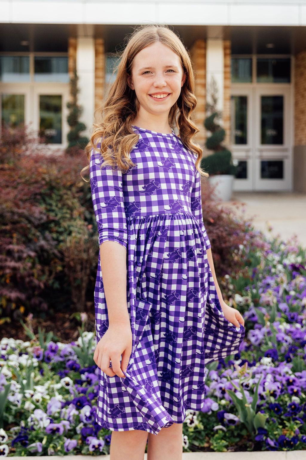 a girl in a purple and white checkered dress