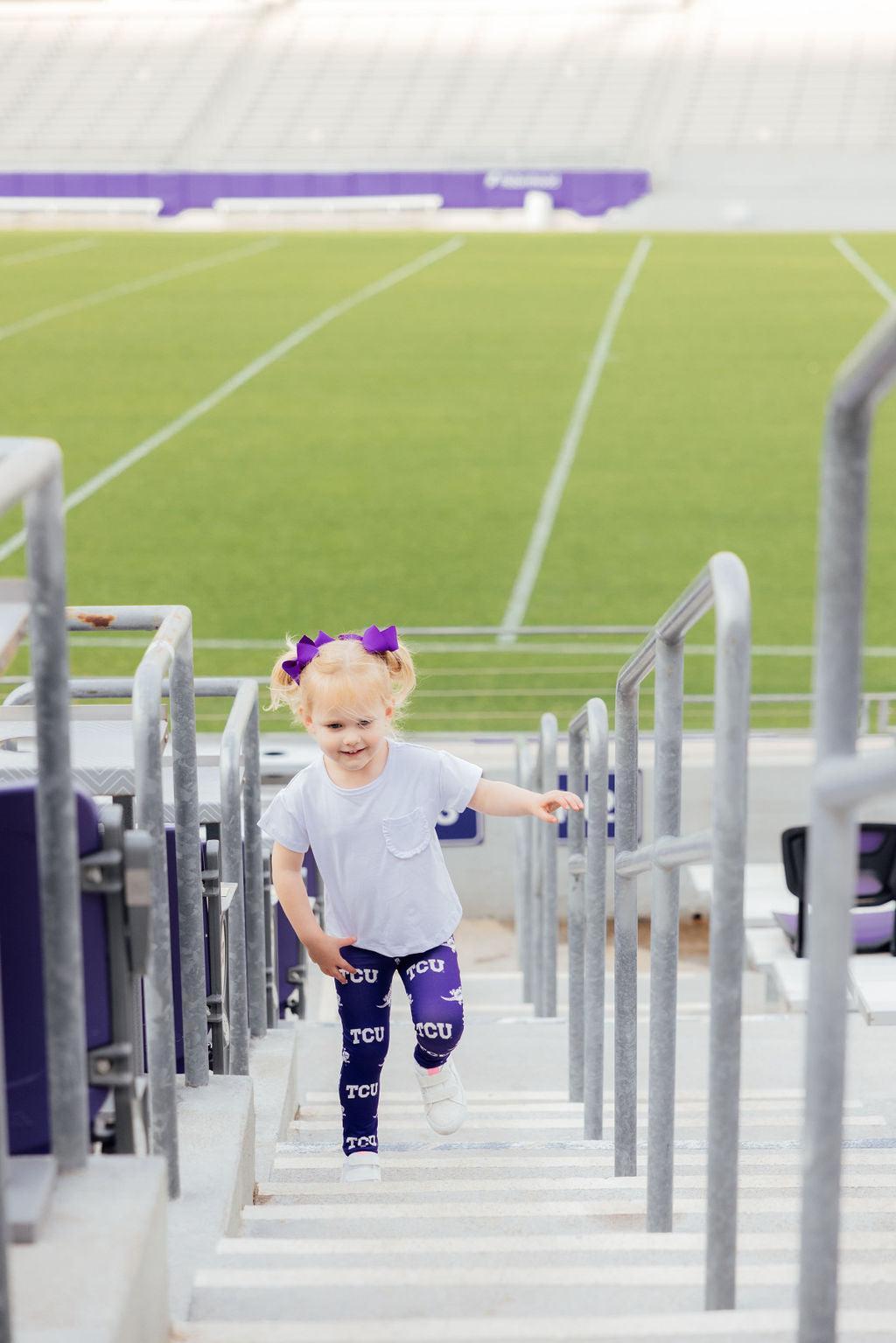a girl walking up stairs on a stadium