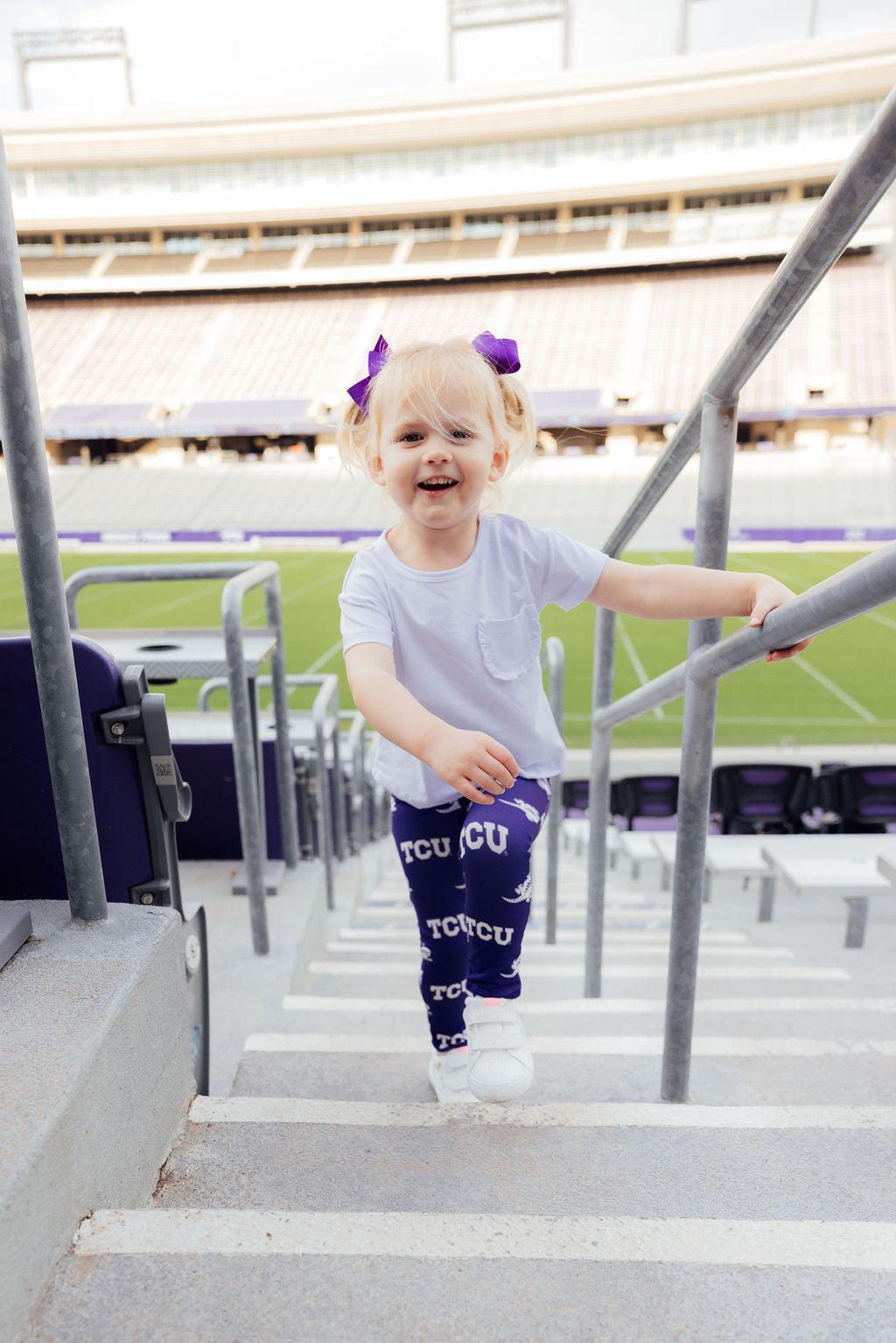 a girl climbing up stairs in a stadium
