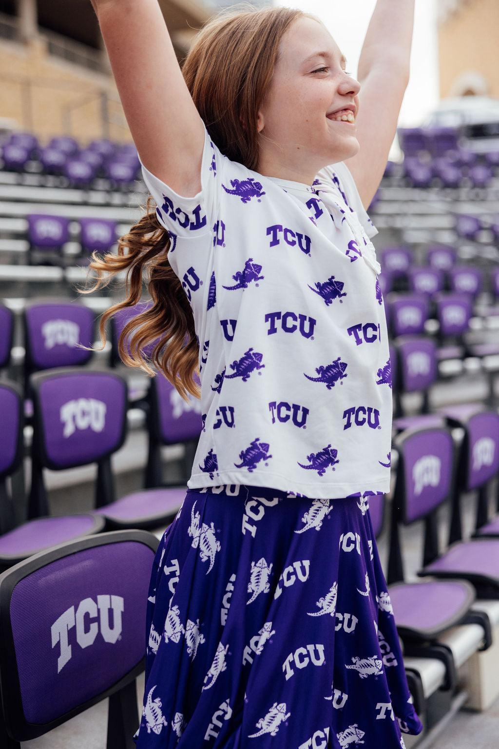 a woman in a white shirt and purple skirt