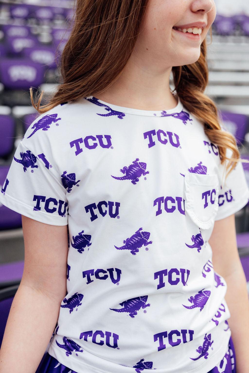 a girl wearing a white shirt with purple dinosaur designs