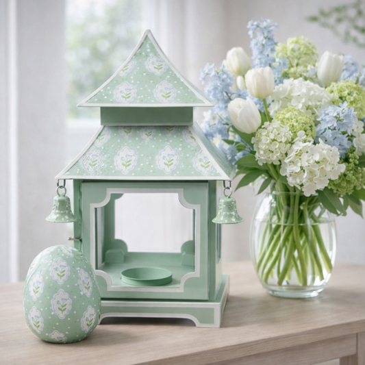 a green lantern and a vase of flowers