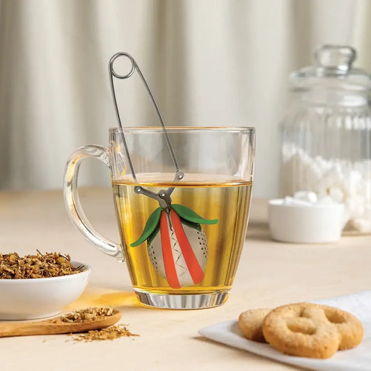 a glass mug with a safety pin in it