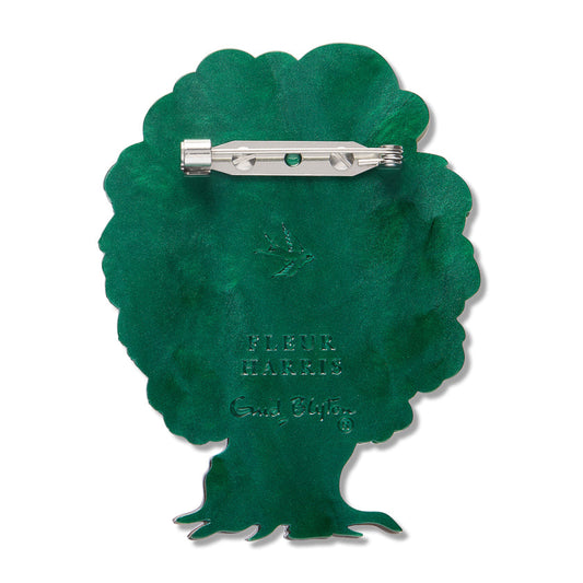 a green brooch with a silver metal pin