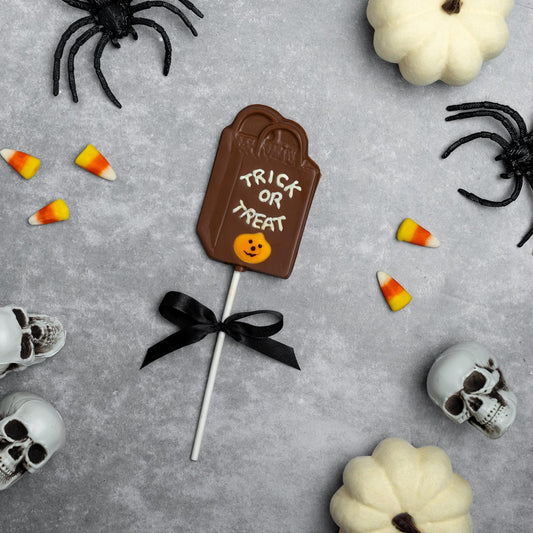 a chocolate candy on a stick surrounded by skulls and candy