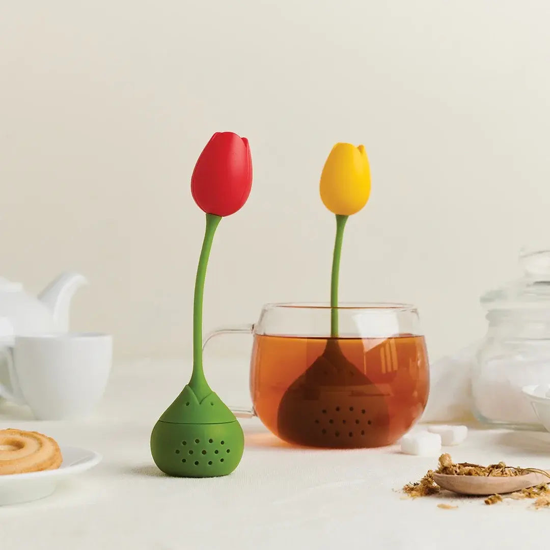 a tea strainer with tulips in it