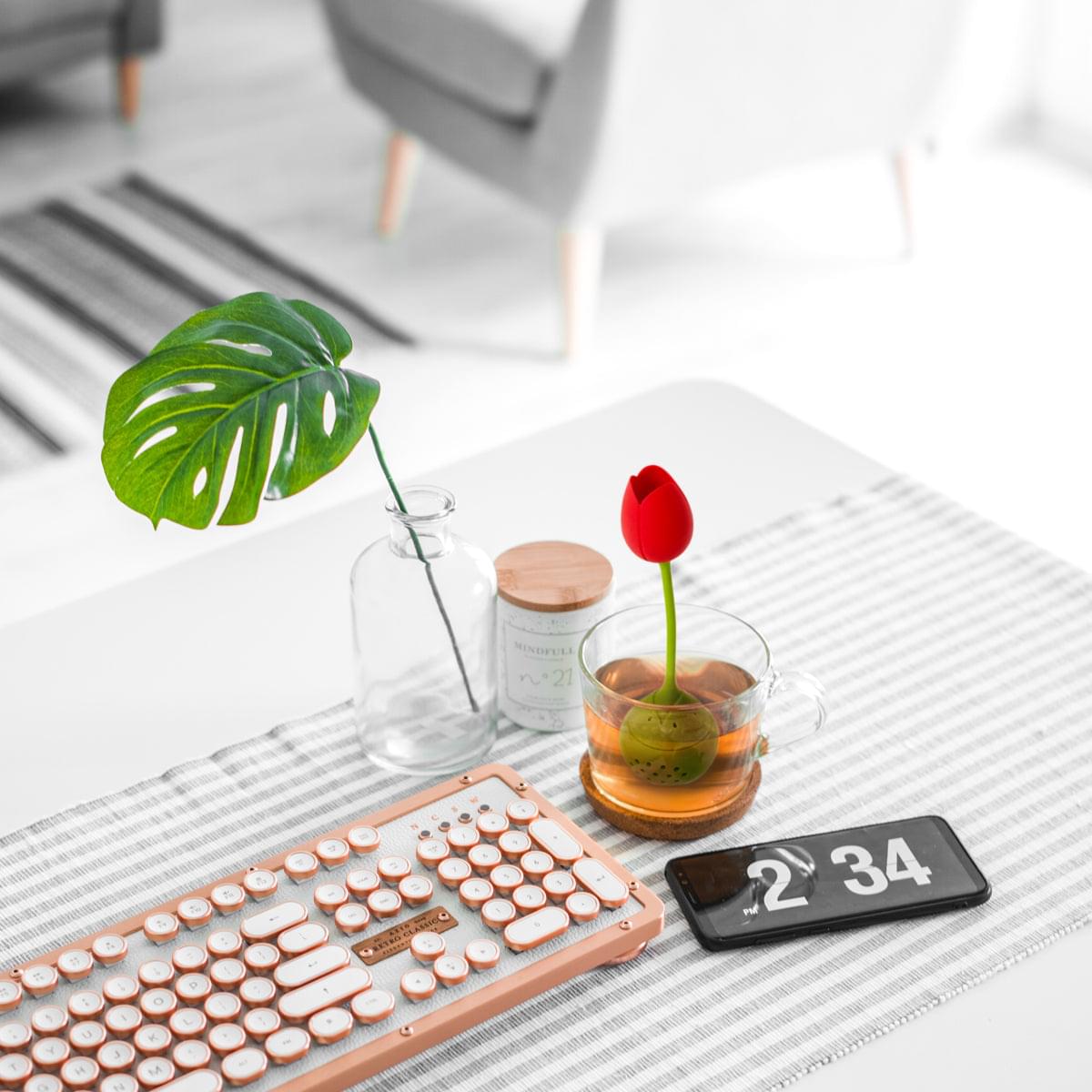 a keyboard and a flower on a table