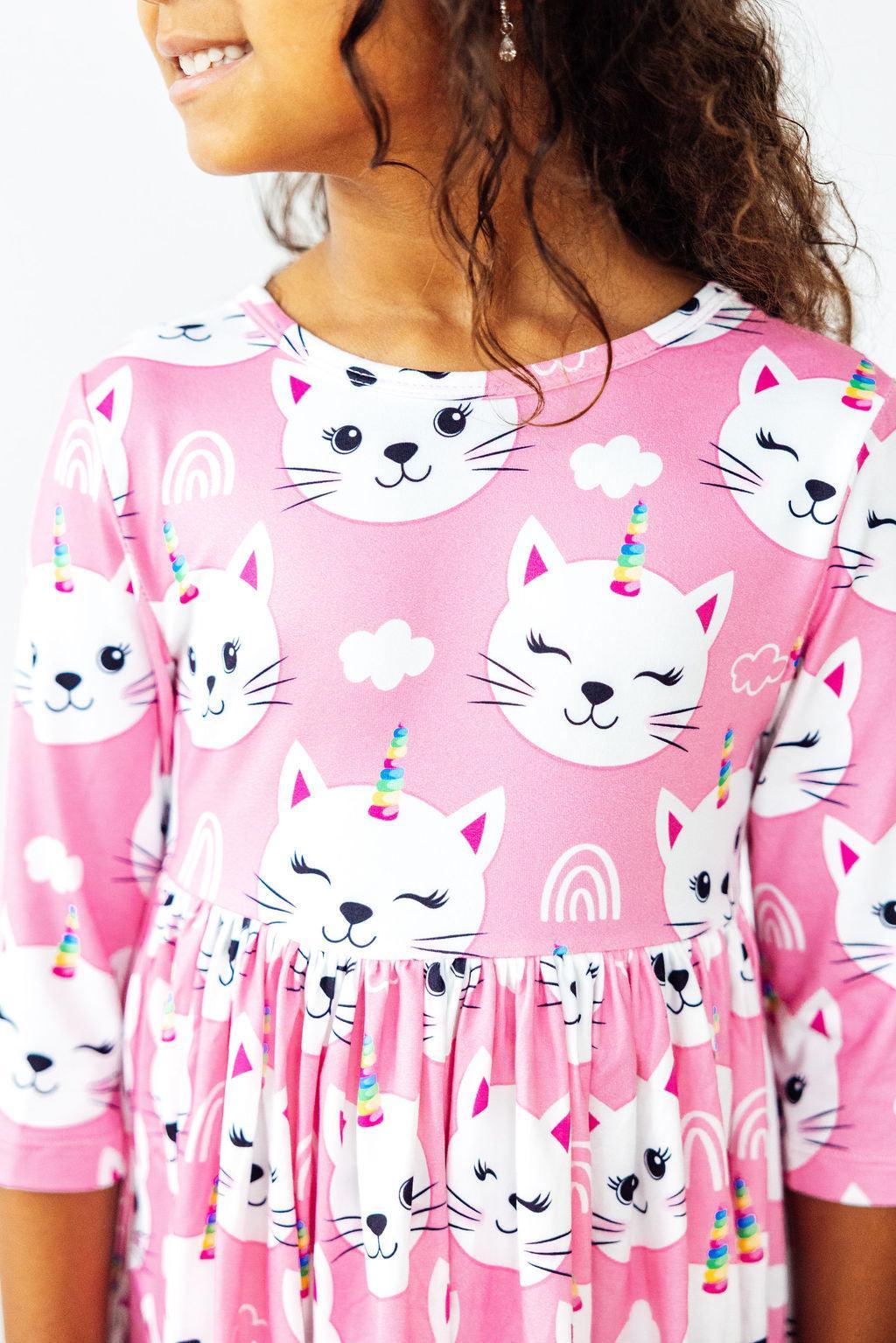 a girl wearing a pink dress with cat faces