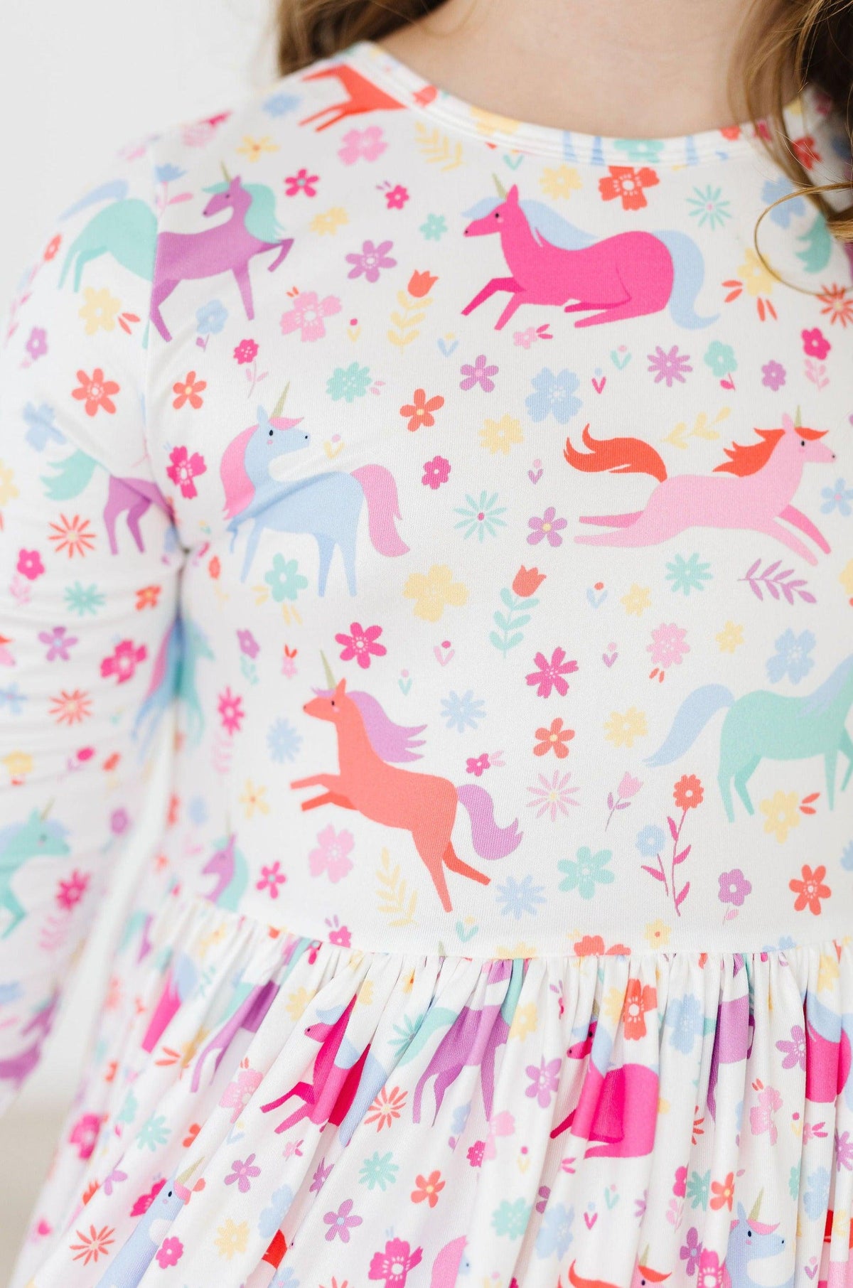 a girl wearing a dress with unicorns and flowers
