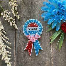 a blue and red ribbon with white text and flowers