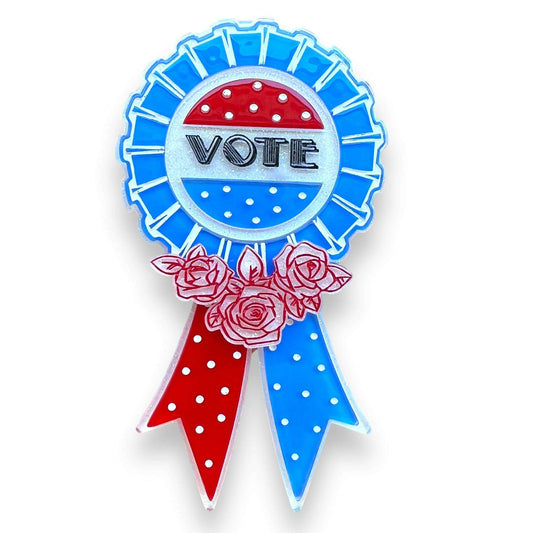 a blue and red badge with red and white polka dots and flowers