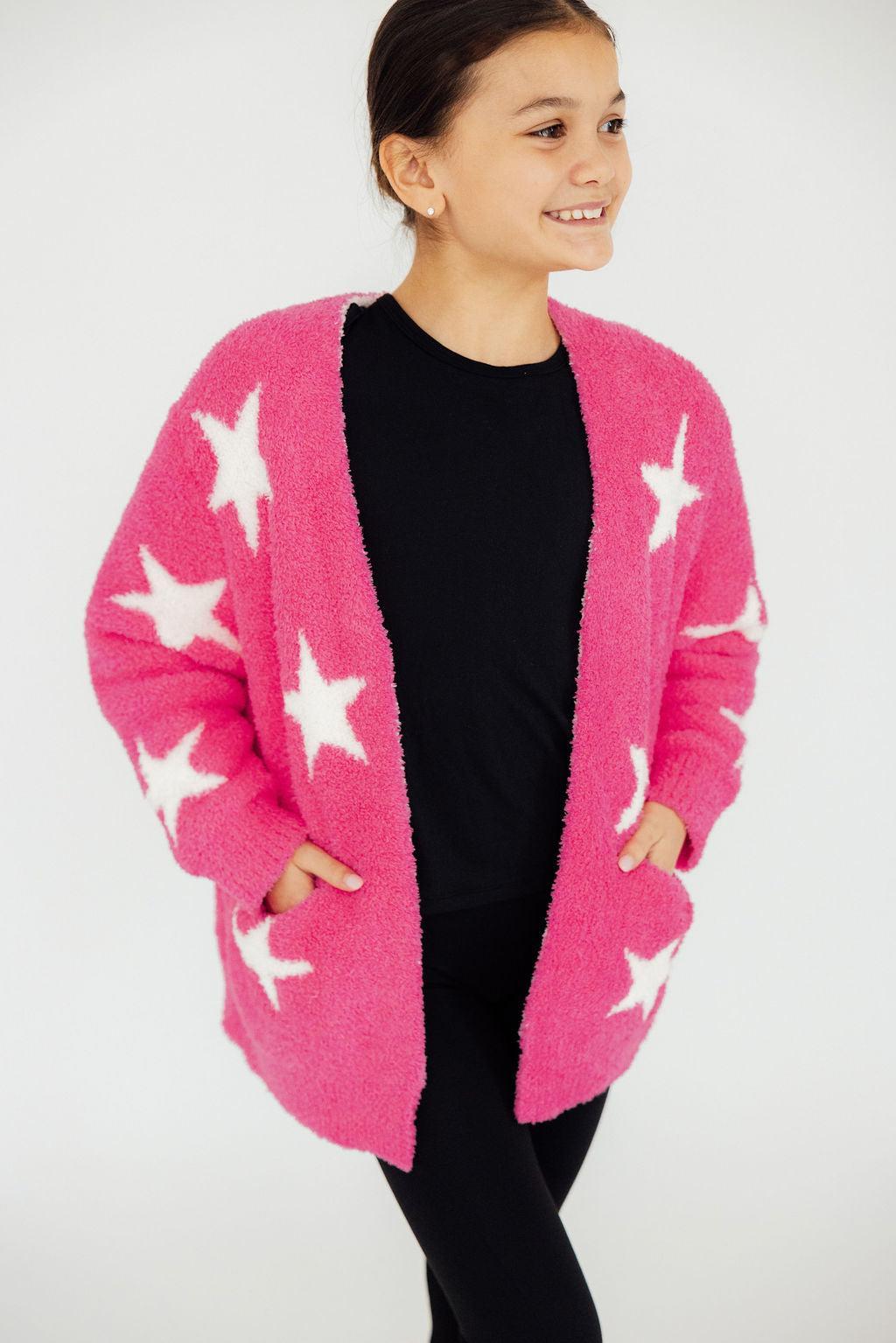 a woman in a pink cardigan with white stars